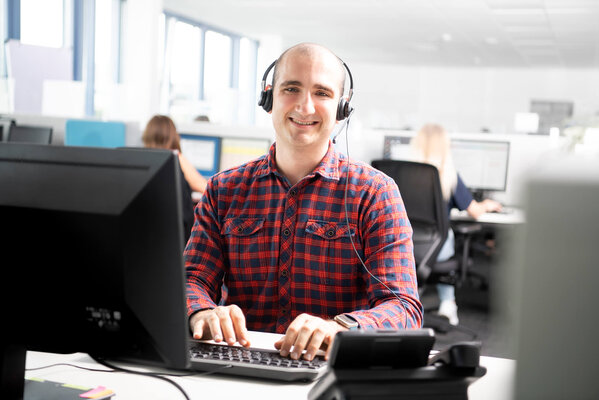 Kundenberater telefoniert über Headset mit Kunden